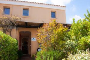 uma casa com uma porta e alguns arbustos em Valesmeralda Boutique Rooms em Porto Cervo