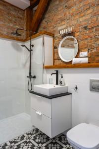 a bathroom with a white sink and a mirror at Apartamenty toruńskie pod Krzywą Wieżą in Toruń