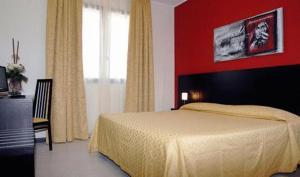 a bedroom with a bed and a red wall at Hotel Del Brembo in Osio Sotto