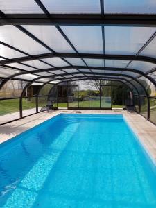 an overhead swimming pool with a metal roof at L Eskemm in Plouaret