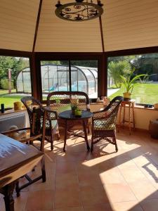 a screened in porch with chairs and a table at L Eskemm in Plouaret