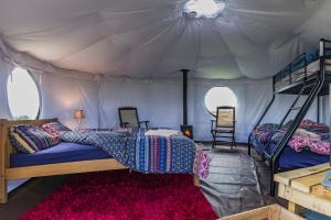 a bedroom with two beds in a tent at Mousley House Farm Campsite and Glamping in Warwick