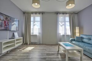 ein Wohnzimmer mit einem blauen Sofa und einem Tisch in der Unterkunft Apartament Gemini in Dzierżoniów