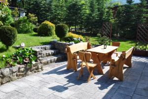 a wooden table and chairs sitting on a patio at Domek u Domny in Kowary