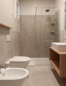 a bathroom with a toilet and a sink and a shower at Appartamento Stelvio in Morbegno