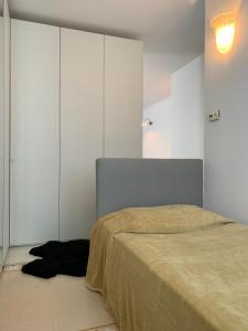 a black dog laying on a bed in a room at Masnadieri 18 in Parma