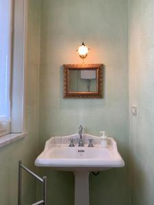 a bathroom with a sink and a mirror at Masnadieri 18 in Parma