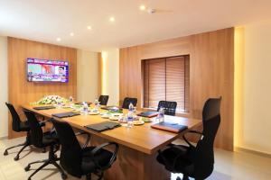 a conference room with a large wooden table and chairs at JK Park Residency Kannur in Kannur +4 photos