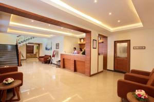 a lobby of a hospital with people standing at a counter at JK Park Residency in Kannur