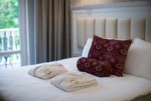 a bed with towels on it with a pillow at Hotel Passport Tbilisi in Tbilisi City