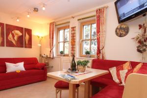 ein Wohnzimmer mit einem roten Sofa und einem Tisch in der Unterkunft Ferienwohnungen Anita in Fieberbrunn