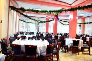 un salón de banquetes con mesas y sillas y adornos navideños en Hotel Bradul en Durau