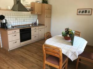a kitchen with a table with chairs and a table with flowers on it at Ferienwohnung Scherr in Neunburg vorm Wald