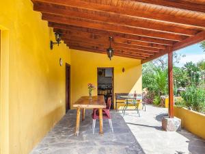 eine Terrasse mit einem Holztisch und einer gelben Wand in der Unterkunft Holiday Home Camino La Candelaria-1 by Interhome in La Orotava