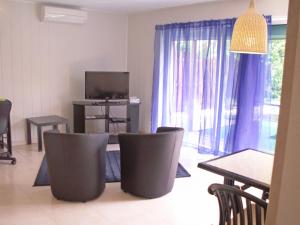 sala de estar con mesa, sillas y TV en Apartment Haider by Interhome, en Caumont-sur-Durance