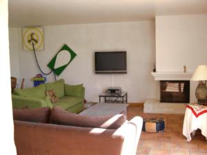 a living room with a green couch and a television at Holiday Home La Grèze by Interhome in Saint-Just