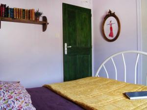a bedroom with a green door and a bed and a table at Holiday Home Du Brun by Interhome in Bésignan