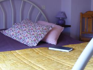 a bed with a pillow and a remote control on it at Holiday Home Du Brun by Interhome in Bésignan