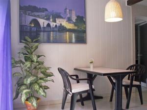 una mesa y sillas en una habitación con una foto en la pared en Apartment Haider by Interhome, en Caumont-sur-Durance