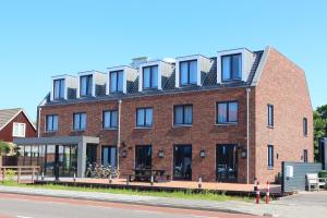 a red brick building with windows on a street at Blue Mansion Hotel in Aalsmeer
