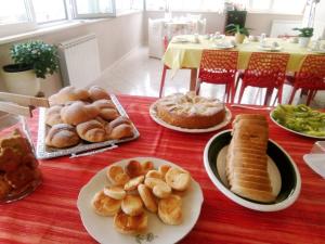 a table with plates of bread and pastries on it at B&b la finestra sul mare in Capo dʼOrlando