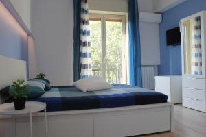 sypialnia z łóżkiem z niebieskimi ścianami i oknem w obiekcie b&b Appiddaveru w Katanii