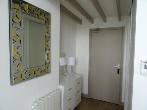 a mirror on a wall next to a door at ORATORIENS HENRI IV in Dieppe