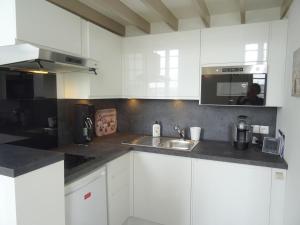 a white kitchen with a sink and a microwave at ORATORIENS HENRI IV in Dieppe +10 photos
