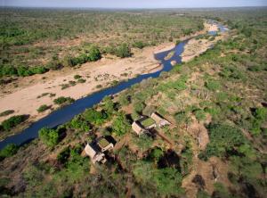 uma vista aérea de um rio com casas numa colina em Lion Sands Ivory Lodge em Sabi Sand Game Reserve