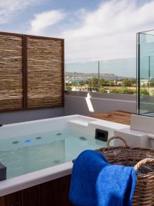 a bath tub in a room with a large window at Lymberia Hotel in Faliraki