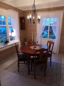 uma sala de jantar com uma mesa de madeira e cadeiras em Fjords view em Sjøholt