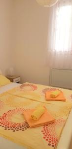 duas toalhas estão sentadas em cima de uma cama em Apartments Korana, BelajskePoljice em Duga Resa