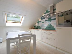 uma cozinha com armários brancos, uma mesa e uma janela em Quaint Apartment in Vielsalm with Private Terrace em Vielsalm