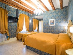 two beds in a room with blue walls at Dimora Marciana in Venice