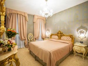 1 dormitorio con cama y lámpara de araña en Dimora Marciana, en Venecia