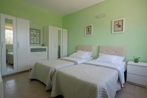 2 Betten in einem Zimmer mit grünen Wänden in der Unterkunft SESI VIEW in Grammatiko