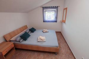 a small bedroom with a bed and a window at Apartments Ezra in Gradac