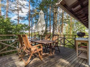 une table et des chaises sur une terrasse arborée dans l'établissement Holiday Home Artturin mökki by Interhome, à Kylmälä