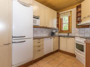 a kitchen with white cabinets and a refrigerator at Holiday Home Juhala by Interhome in Kilvakkala