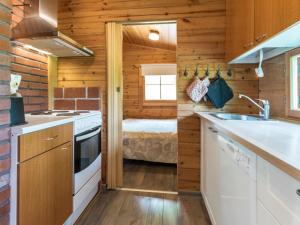 a kitchen with a sink and a bed in a room at Holiday Home Kasilahti by Interhome in Kilvakkala