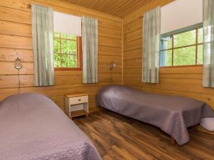 2 camas en una habitación con paredes y ventanas de madera en Holiday Home Juhala by Interhome, en Kilvakkala 14 fotos más