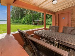 eine Veranda mit einer Holzbank und einem Pavillon in der Unterkunft Holiday Home Kasilahti by Interhome in Kilvakkala
