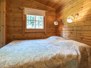 ein Schlafzimmer mit einem Bett in einer Blockhütte in der Unterkunft Holiday Home Kasilahti by Interhome in Kilvakkala + 13 Fotos