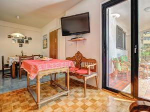 a dining room with a table and a tv at Apartment Iris Croatica by Interhome in Veruda
