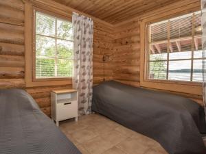 KilvakkalaにあるHoliday Home Juusola by Interhomeのログキャビン内のベッドルーム1室(ベッド2台付)