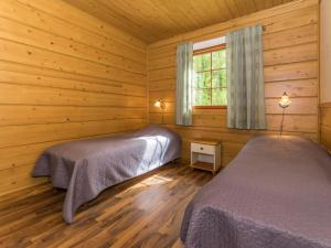 KilvakkalaにあるHoliday Home Juhala by Interhomeのログキャビン内のベッドルーム1室(ベッド2台付)
