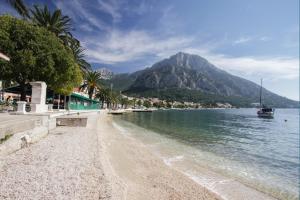 a beach next to the water with a mountain at Apartments Ezra in Gradac