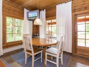 ein Esszimmer mit einem Holztisch und Stühlen in der Unterkunft Holiday Home Kasilahti by Interhome in Kilvakkala