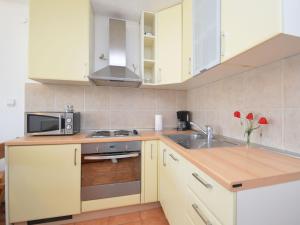 a kitchen with white cabinets and a sink and a microwave at Holiday Home Martina by Interhome in Valdebek +18 photos