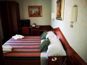 a hotel room with a bed and a desk at Hotel Royal in Bolsena